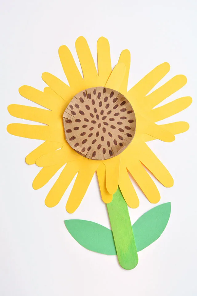 Handprint crafts for kids: sunflower craft made from yellow handprints with a brown centre and green stem